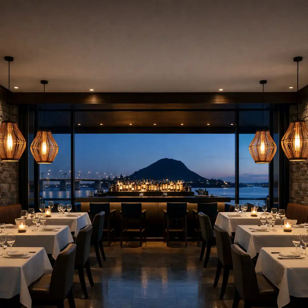 Contemporary coastal restaurant interior with stone walls, dark timber, harbour views at dusk, and sculptural pendant lights